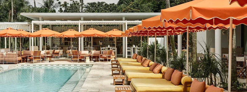 Orange parasols and yellow daybeds at Tanjong Beach Club, Singapore